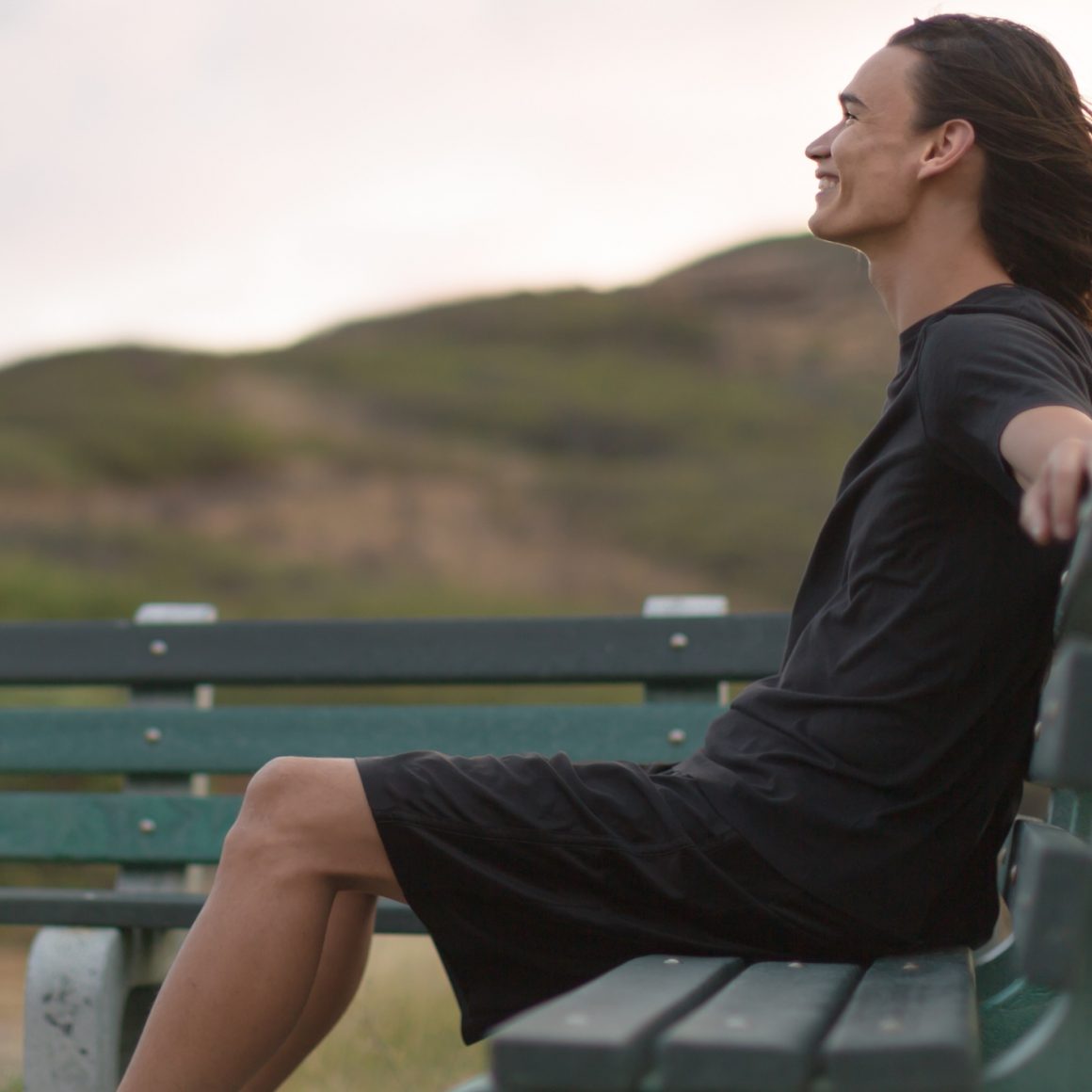 Young man on a bench smiling